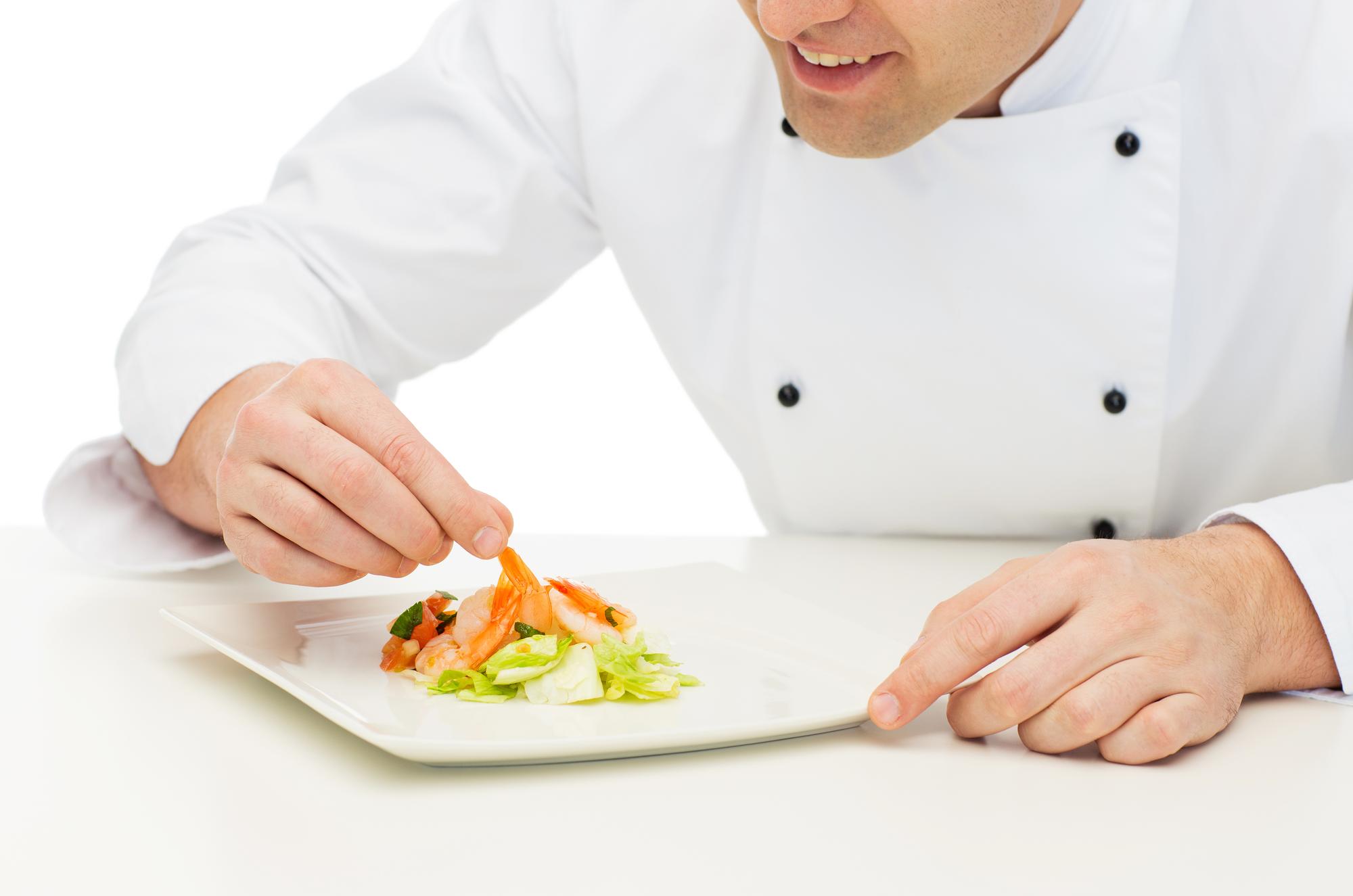 Chef preparing plated dish in minimalist kitchen
