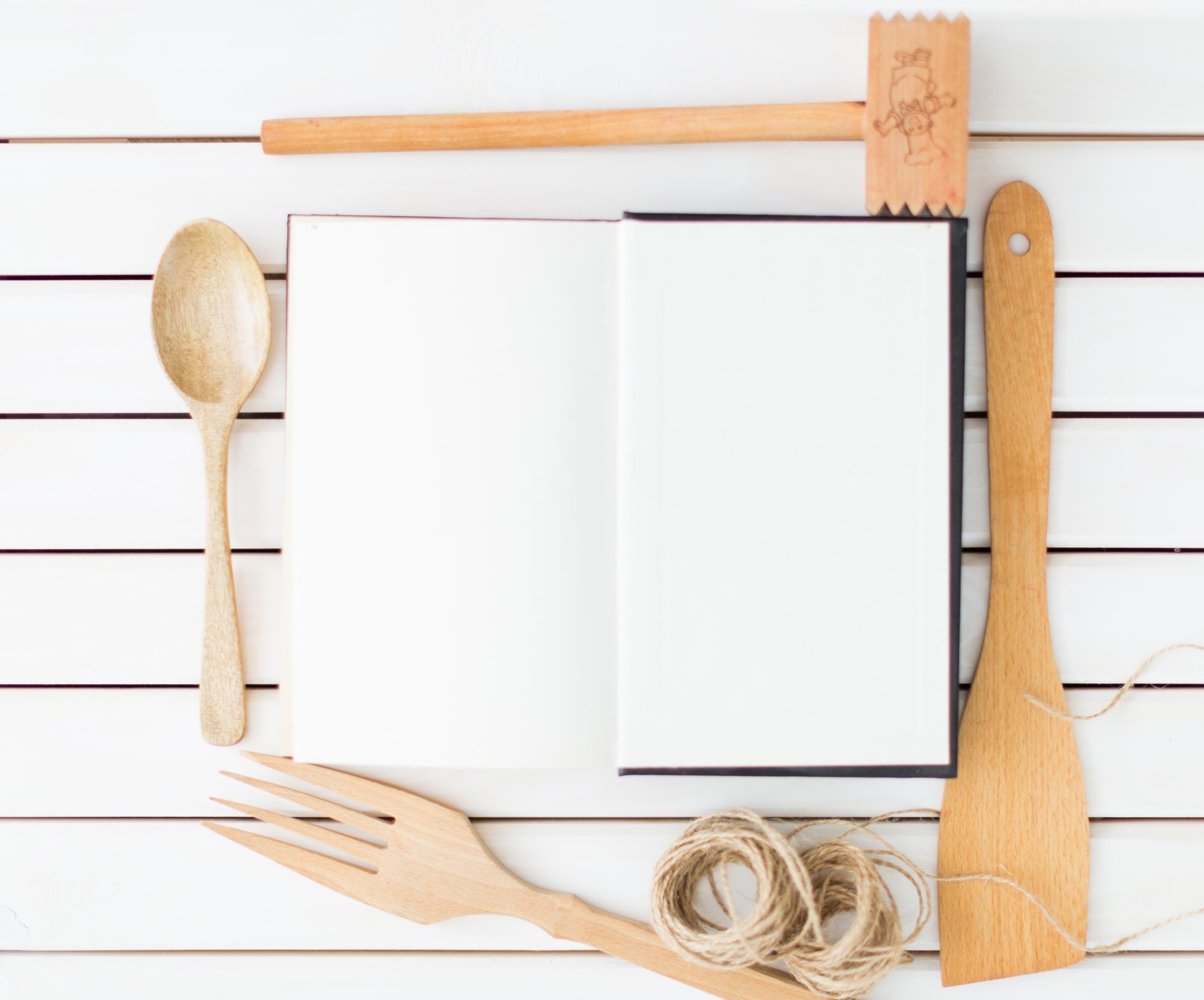Open cookbook and utensils on table